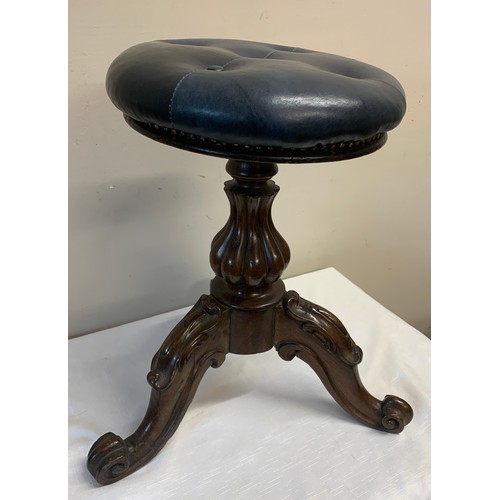 1130 - Victorian swivel topped piano stool, upholstered in blue buttoned leather. 49cm h.