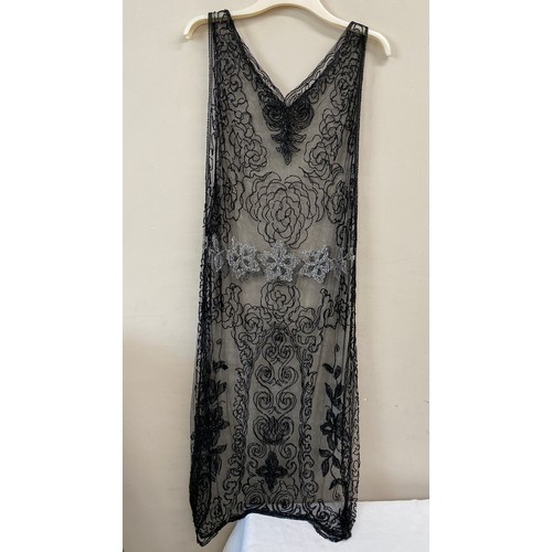 500 - A 1920's beadwork dress, the net ground embellished with black and clear bugle beads. Approx 120 cm ... 