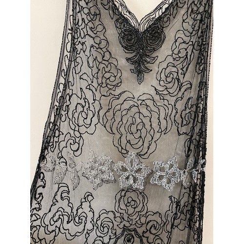 500 - A 1920's beadwork dress, the net ground embellished with black and clear bugle beads. Approx 120 cm ... 