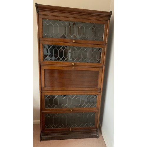 1144 - A 5 section mahogany and leaded glass modular bookcase with desk to centre. Glass doors slide up and... 