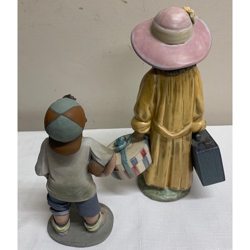 114 - A Lladro figurine, a girl with  suitcase and hatbox 28cm h together with an Elisa figure of a boy wi... 