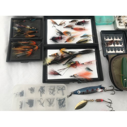 767 - Quantity of fly fishing feather hooks with cases, spinning lures and treble hooks and a cloth bag.