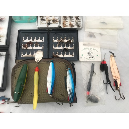 767 - Quantity of fly fishing feather hooks with cases, spinning lures and treble hooks and a cloth bag.