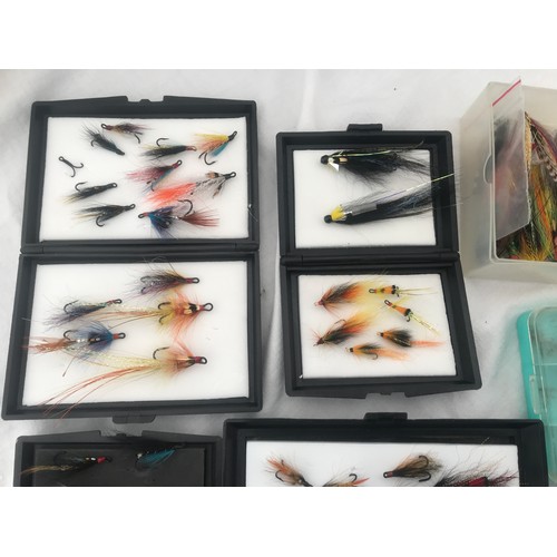 767 - Quantity of fly fishing feather hooks with cases, spinning lures and treble hooks and a cloth bag.