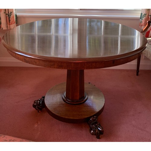 1155 - A 19thC mahogany circular tip-top centre table on paw feet. One metre d.