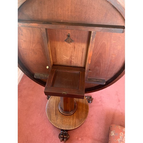 1155 - A 19thC mahogany circular tip-top centre table on paw feet. One metre d.