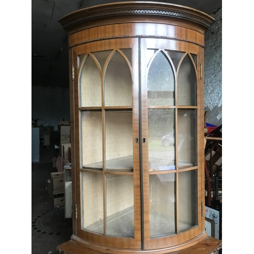 1174 - Walnut bow front corner cabinet, 2 glazed door top, 2 door base, claw and ball feet.