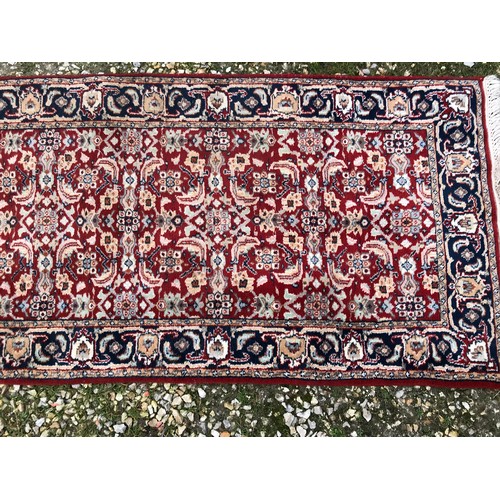 514 - Red ground wool floral pattern runner rug 270cm l x 81cm w.