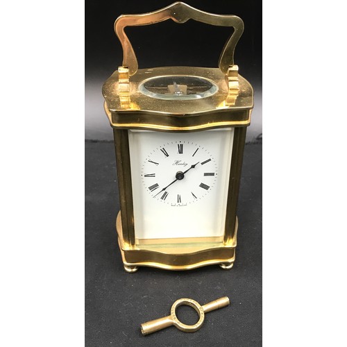 799 - A Henley brass carriage clock with original key case. 16cm h with handle x 8.5cm w x 7cm d.