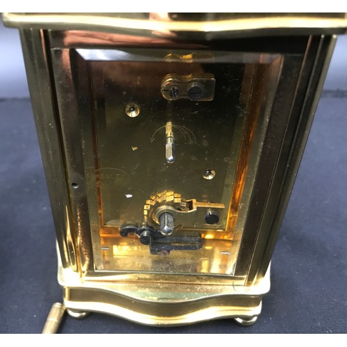 799 - A Henley brass carriage clock with original key case. 16cm h with handle x 8.5cm w x 7cm d.