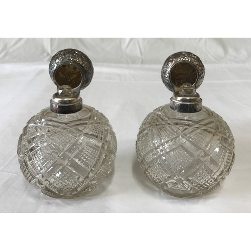 530 - Two silver topped cut glass scent bottles with floral pattern to silver, Birmingham 1909 and spheric... 