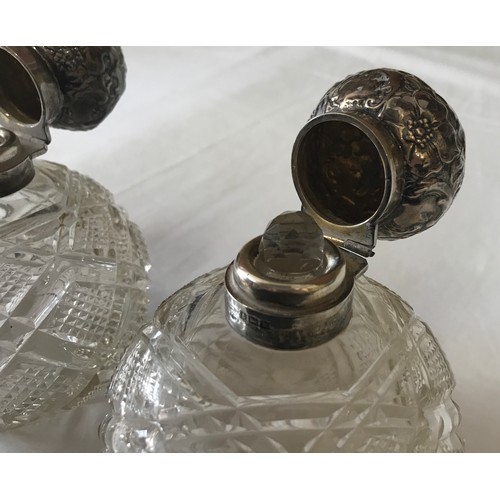 530 - Two silver topped cut glass scent bottles with floral pattern to silver, Birmingham 1909 and spheric... 