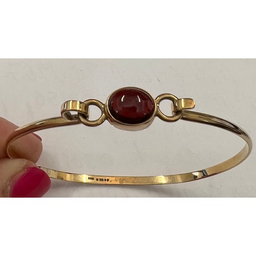 342 - A gold bangle set with single red stone marked .375. 5.4gms total.