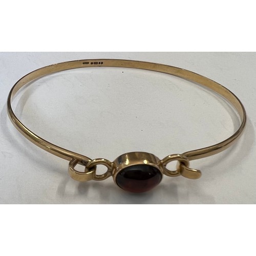 342 - A gold bangle set with single red stone marked .375. 5.4gms total.