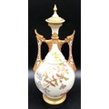 A Royal Worcester lidded vase with floral decoration and pierced dragon headed handles. 41cms.