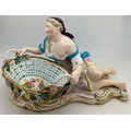 A John Bevington figural sweetmeat basket modelled as a classical lady seated by a shell shaped oval... 