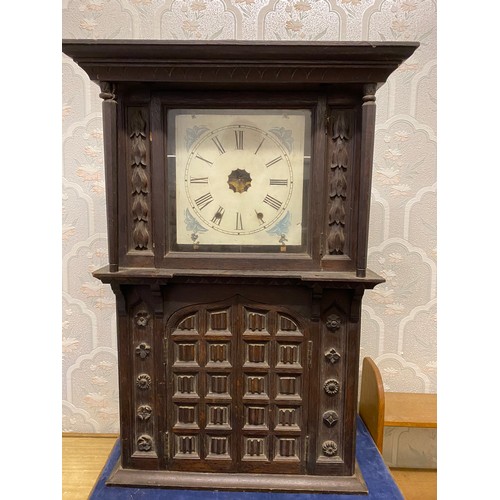 815 - A carved oak wall clock with opening doors to base.