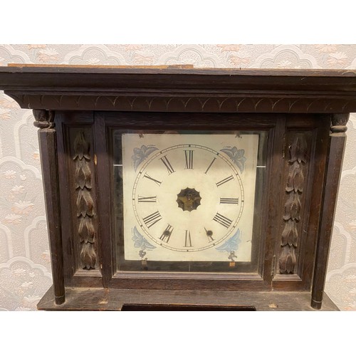 815 - A carved oak wall clock with opening doors to base.