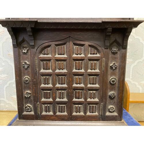 815 - A carved oak wall clock with opening doors to base.