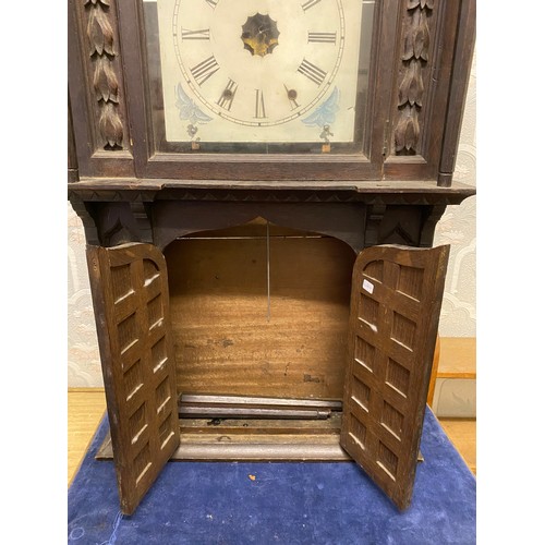 815 - A carved oak wall clock with opening doors to base.