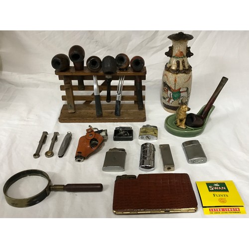 855 - Smoking ephemera to include 7 pipes and rack, a Wade ceramic dog pipe holder, 8 lighters (various de... 