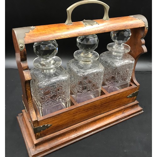 303 - Oak cased, brass mounted three bottle tantalus with key, 36cm h to handle, base 39 w x 17cm d.