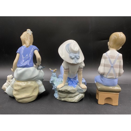 70 - Five various Lladro Nao figurines. Tallest seated girl with 2 puppies 18cm h.