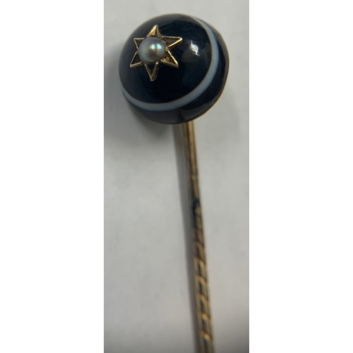 353 - Banded agate and seed pearl mourning stick pin set on yellow metal.