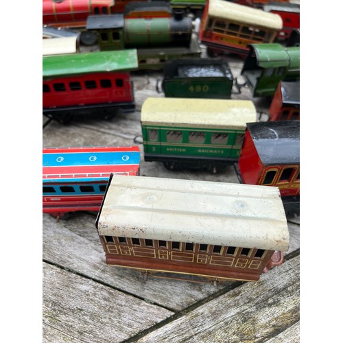 715 - A collection of Tin Plate railway items including trains, carriages/wagons etc.