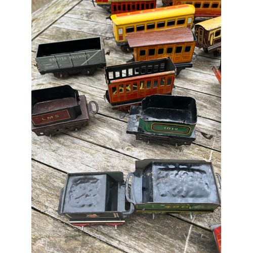 715 - A collection of Tin Plate railway items including trains, carriages/wagons etc.