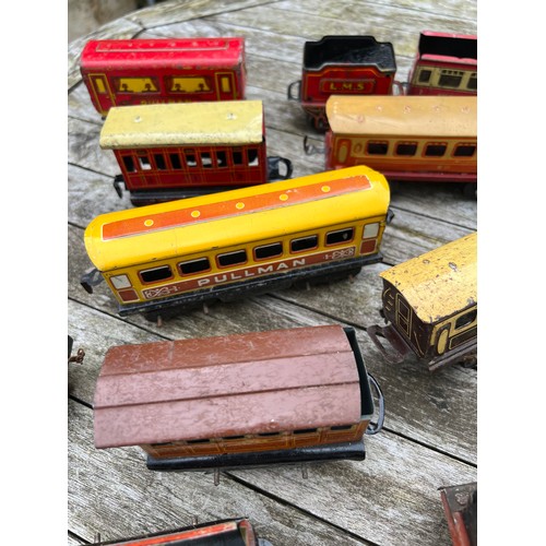 715 - A collection of Tin Plate railway items including trains, carriages/wagons etc.