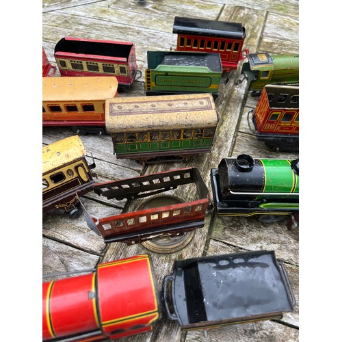 715 - A collection of Tin Plate railway items including trains, carriages/wagons etc.