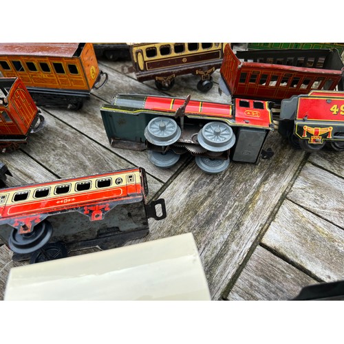 715 - A collection of Tin Plate railway items including trains, carriages/wagons etc.