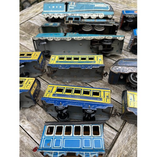 721 - Tin plate clockwork train and carriages to include Merlin 60027 x 2, Dominion of Canada 4491, 4489, ... 