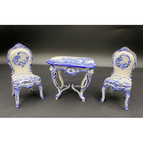 90 - Continental porcelain miniature blue and white furniture. Two small tables with marks to base.