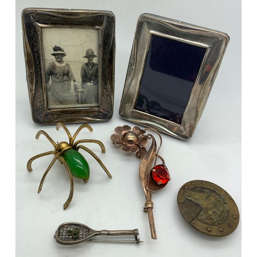 557 - Two silver frames, Birmingham 1923, together with three brooches, two silver and one brass and a but... 