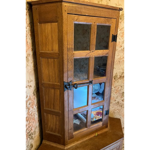 785 - Peter Heap Rabbitman , an oak standing corner cupboard, panelled with a glazed door over a panelled ... 