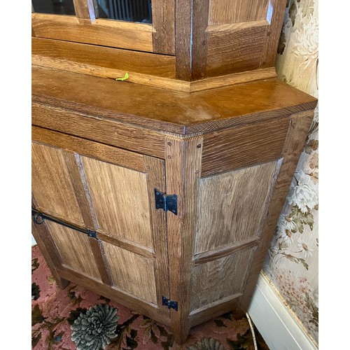 785 - Peter Heap Rabbitman , an oak standing corner cupboard, panelled with a glazed door over a panelled ... 