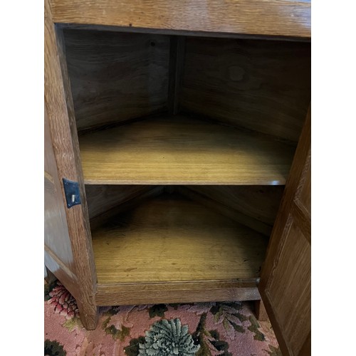 785 - Peter Heap Rabbitman , an oak standing corner cupboard, panelled with a glazed door over a panelled ... 