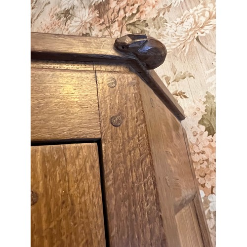 785 - Peter Heap Rabbitman , an oak standing corner cupboard, panelled with a glazed door over a panelled ... 