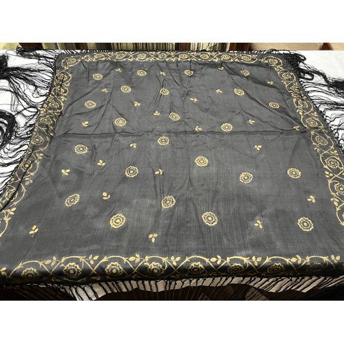 499 - A vintage black silk fringed shawl with gold decoration. 94cm square without fringing.