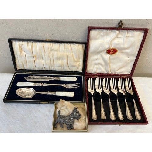 1044 - Boxed cake forks, boxed Mother of Pearl handled spoon knife and fork and a dog brooch.