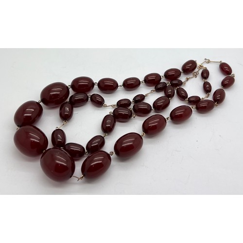 378 - A quantity of cherry amber beads to include 2 necklaces and other loose beads. 164gm total weight.