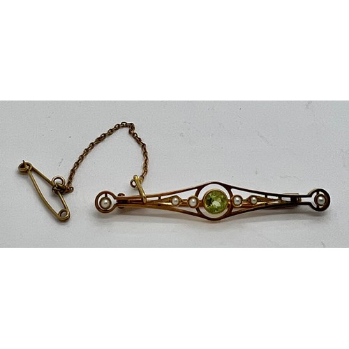 381 - A 15ct seed pearl and peridot bar brooch with safety chain. 3.2gm weight.