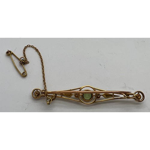 381 - A 15ct seed pearl and peridot bar brooch with safety chain. 3.2gm weight.