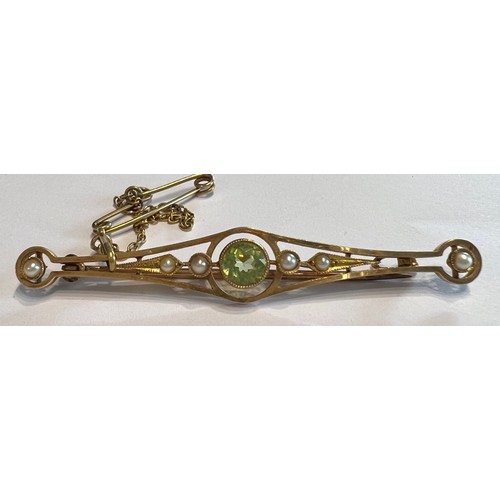 381 - A 15ct seed pearl and peridot bar brooch with safety chain. 3.2gm weight.