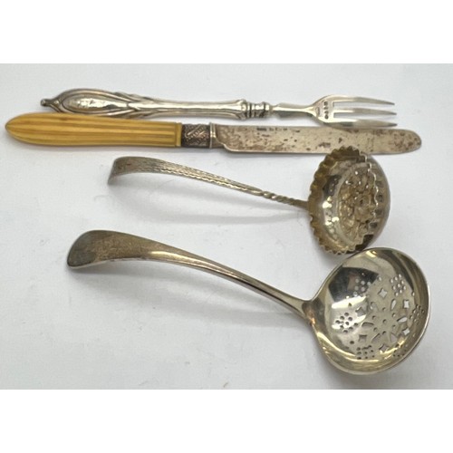 570 - Silver to include; two sifter spoons, silver bladed knife and a fork, sifter with bright cut decorat... 