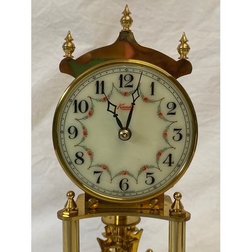 140 - A Kundo clock in glass dome. Height to top of dome 22cm approx.