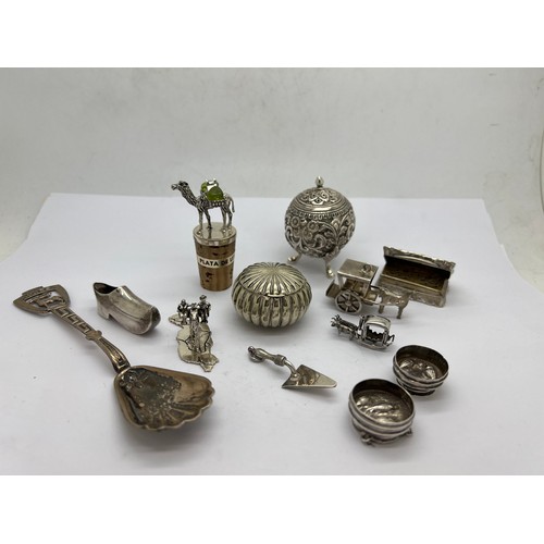 584 - A quantity of unmarked white metal and plated items to include vinaigrette, trowel, pepper pot, clog... 