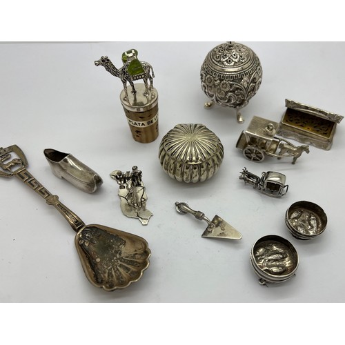 584 - A quantity of unmarked white metal and plated items to include vinaigrette, trowel, pepper pot, clog... 